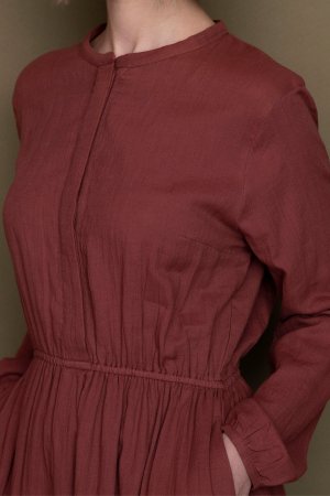 ekologisk klänning fickor dubbelt muslintyg tegelröd modell närbild