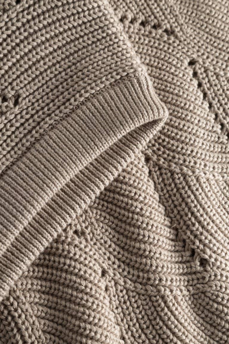 ekologisk väst mönsterstickad bomull lång oversize beige närbild ärmslut